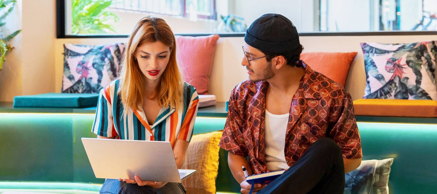 Vrouw en man zitten op een bank en kijken samen naar een laptop